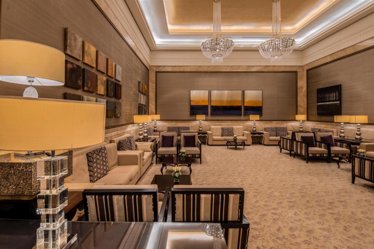 Makkah Clock Royal Tower, A Fairmont Hotel La La Mecca Esterno foto The photo shows a spacious and elegantly designed lounge area. The room features plush seating with cream and beige tones, arranged to create a cozy atmosphere. There are several coffee tables and decorative lamps with a modern design. The walls are 