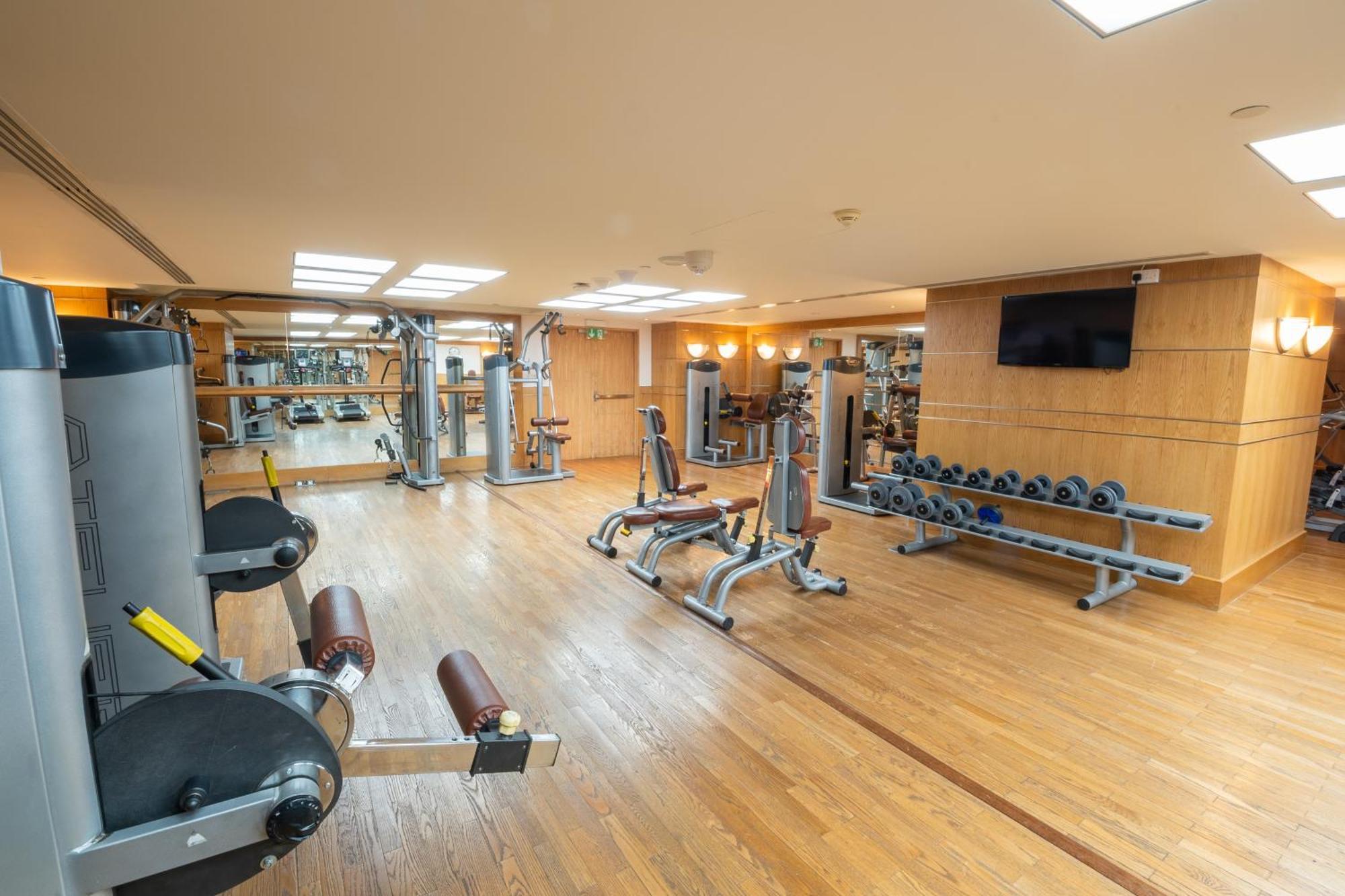 Makkah Clock Royal Tower, A Fairmont Hotel La La Mecca Esterno foto The photo shows a gym interior featuring various exercise equipment. There are weight machines on the left, designed for strength training, and several benches for workouts in the center. A set of dumbbells is neatly arranged on a rack along one wall