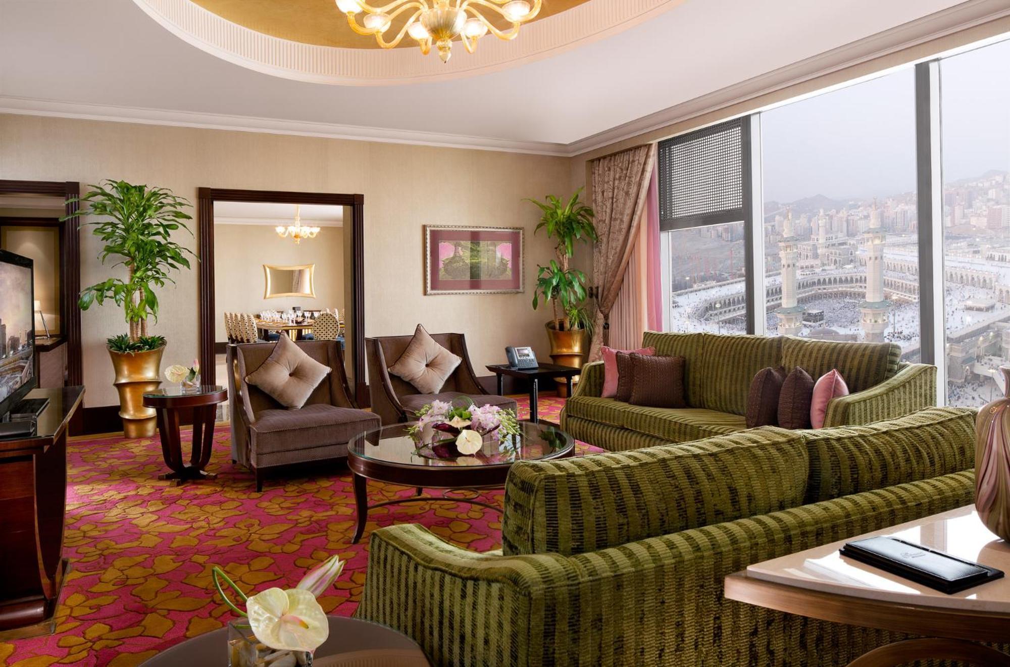 Makkah Clock Royal Tower, A Fairmont Hotel La La Mecca Esterno foto The photo depicts a luxurious hotel suite. The room features a comfortable seating area with a large green sofa and several armchairs arranged around a coffee table. There are decorative plants placed strategically around the room, adding a touch of 