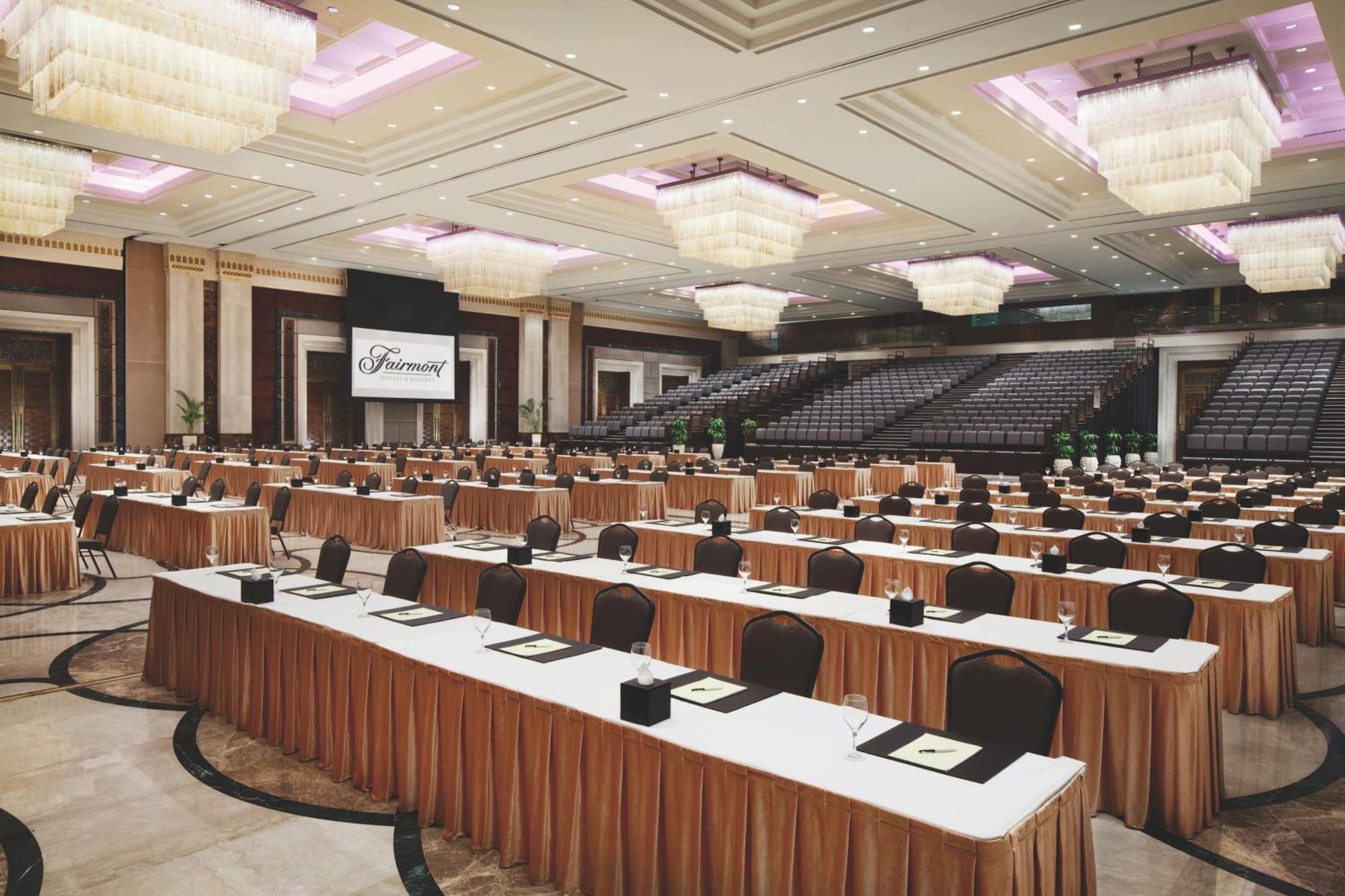 Makkah Clock Royal Tower, A Fairmont Hotel La La Mecca Esterno foto The photo shows a spacious conference room set up for an event. There are several long tables arranged in a U-shape or rows, each covered with white tablecloths and topped with brown table runners. Each table has seating with black chairs and appears