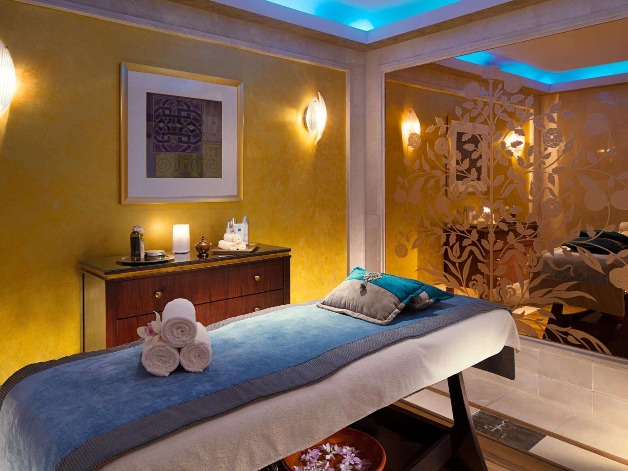 Makkah Clock Royal Tower, A Fairmont Hotel La La Mecca Esterno foto The photo shows a serene spa room designed for relaxation and treatments. There is a massage table covered with a light-colored sheet and a blue throw at the head, along with a decorative pillow. Nearby, a dark wooden cabinet holds candles and spa pr